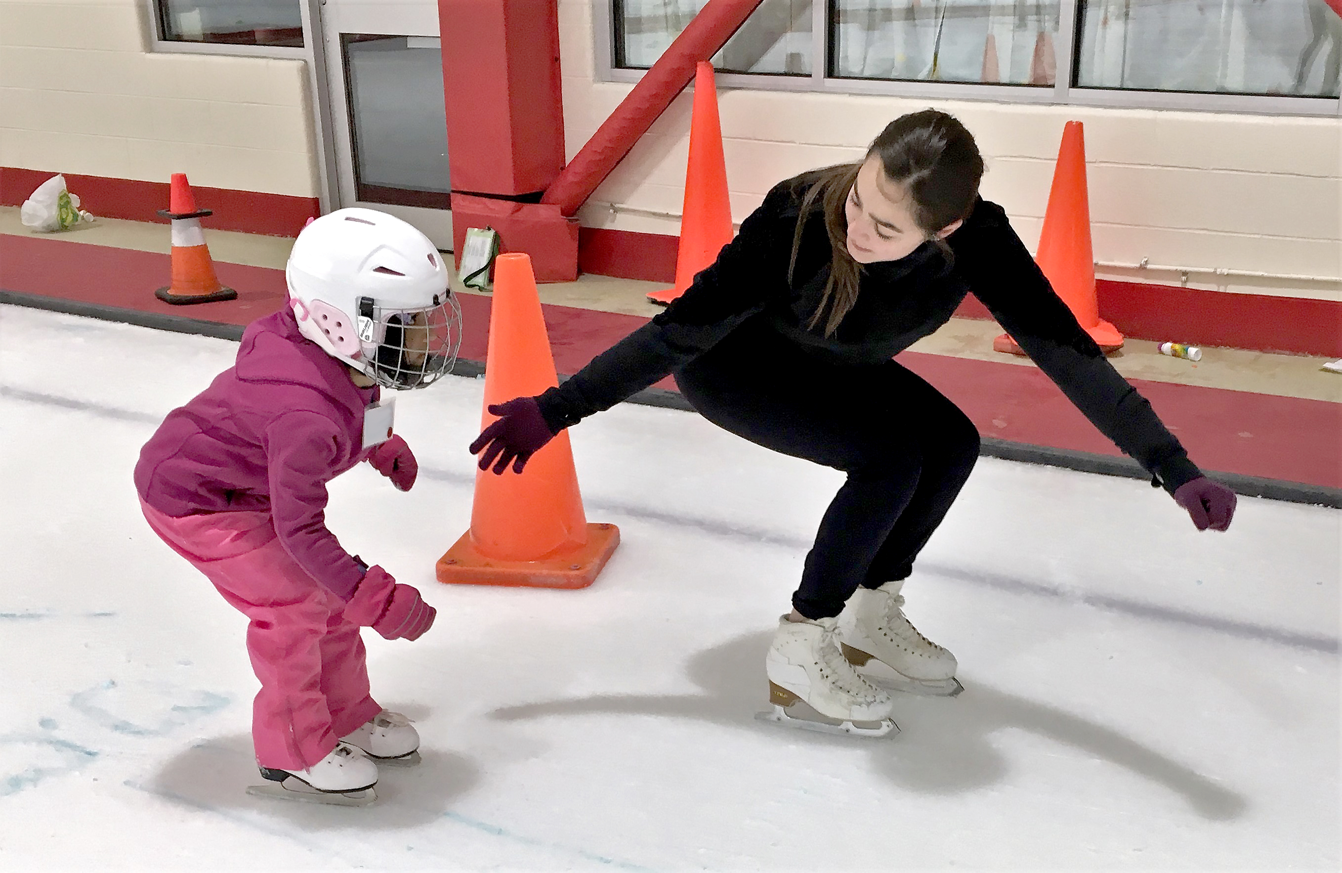Coach helping a beginner skater